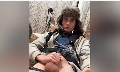 A Guy In A Winter Hat With Earflaps And A Blue Jacket, Masturbates His Penis And Cums With Hot Sperm